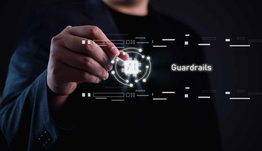 Hand reaching toward a glowing AI emblem surrounded by circuitry and the word 'Guardrails' on a dark tech background.